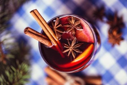 Vianočné teplé víno v pohári s korením a citrusovým ovocím, vianočná atmosféria